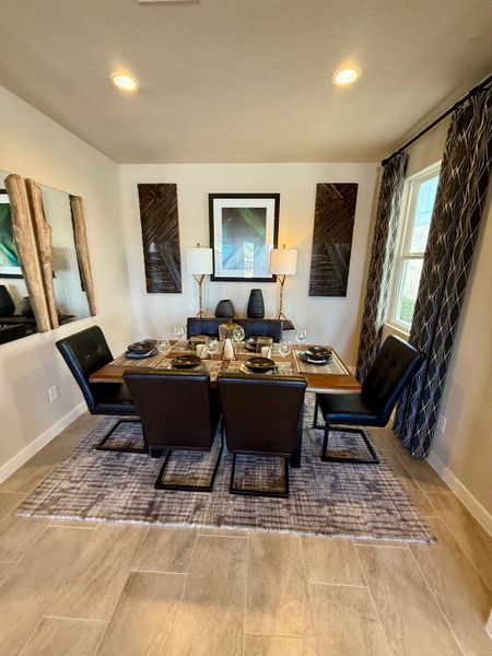 A chic dining room featuring a contemporary table, elegant black chairs, and stylish decor with warm lighting.