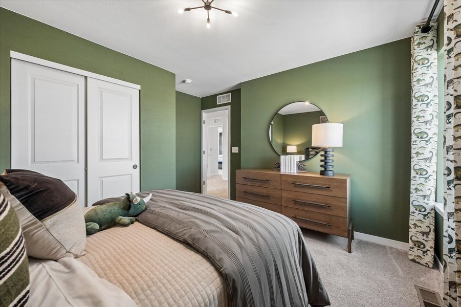 A bedroom with a bed and a mirror.