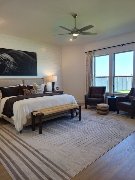 A cozy bedroom featuring a chic shiplap accent wall, plush bedding, and a spacious layout with modern furnishings. A cozy bedroom featuring a chic shiplap accent wall, plush bedding, and a spacious layout with modern furnishings.