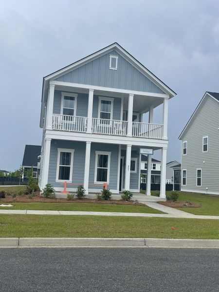 A charming blue two-story home with porch in Carnes Crossroads: Coastal Collection by Lennar (Summerville, SC).