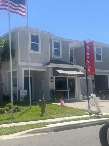 A modern two-story home with a sleek facade and manicured lawn in Horse Creek at Crosswinds by Taylor Morrison (Davenport, FL).