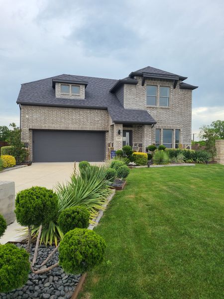A beautiful two-story brick home with manicured landscaping in Eastridge by Trophy Signature Homes (McKinney, TX). A beautiful two-story brick home with manicured landscaping in Eastridge by Trophy Signature Homes (McKinney, TX).