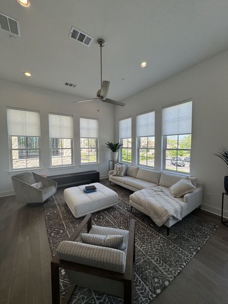 A bright living room with modern seating, large windows, and a stylish gray-patterned rug. A bright living room with modern seating, large windows, and a stylish gray-patterned rug.