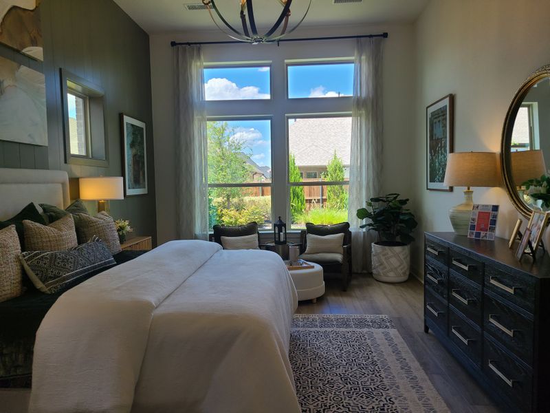 A cozy bedroom featuring a large window, plush bedding, elegant decor, and a stylish dresser with a warm, inviting ambiance. A cozy bedroom featuring a large window, plush bedding, elegant decor, and a stylish dresser with a warm, inviting ambiance.