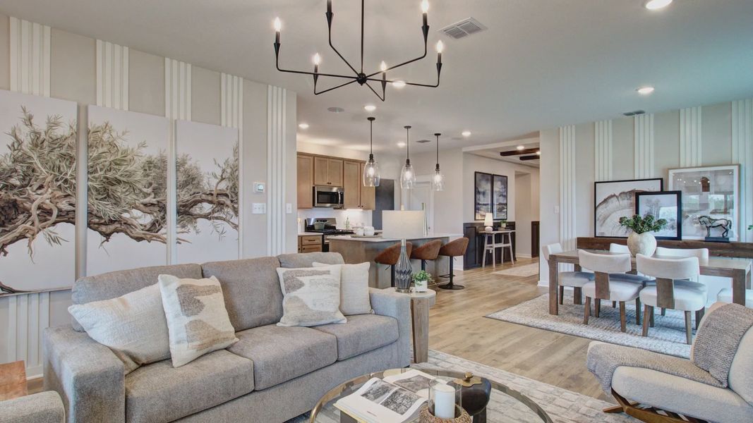 Sophisticated open layout with a striking chandelier, art accents, and premium finishes in Prairie Green community.