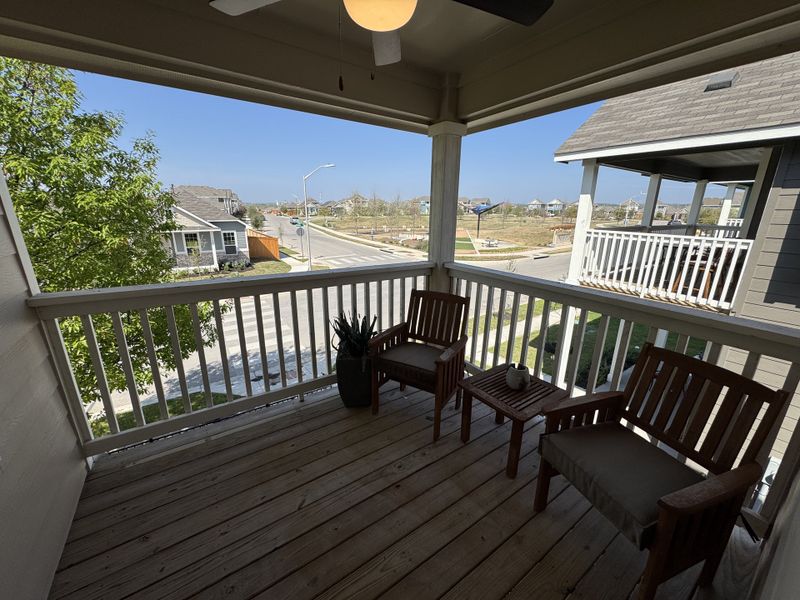 A cozy balcony with wooden chairs offers a neighborhood view, perfect for relaxing in the sun. A cozy balcony with wooden chairs offers a neighborhood view, perfect for relaxing in the sun.