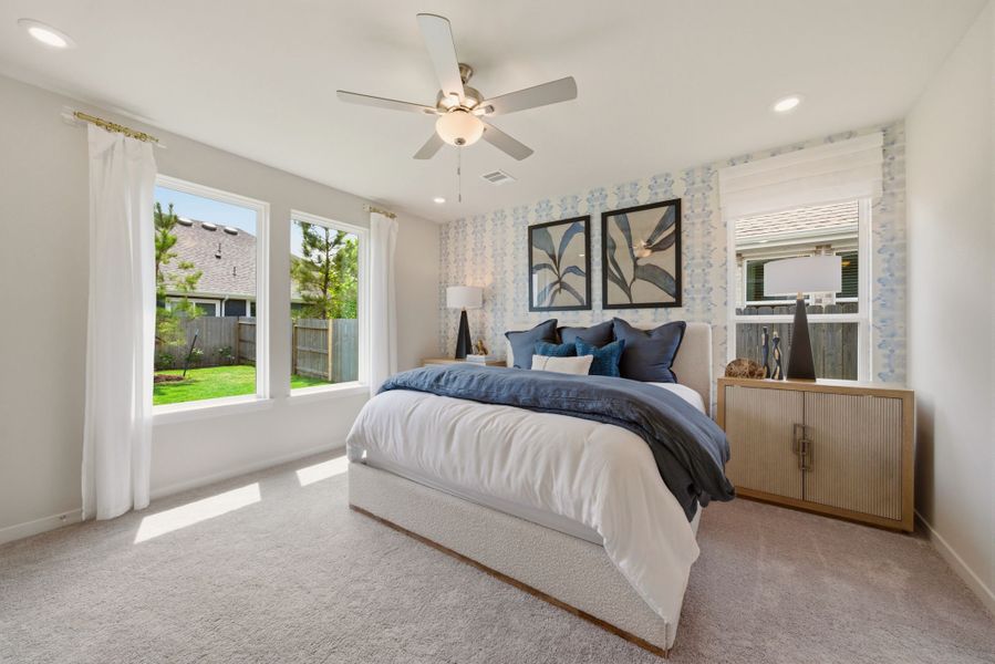 A bedroom with a large bed and a fan.