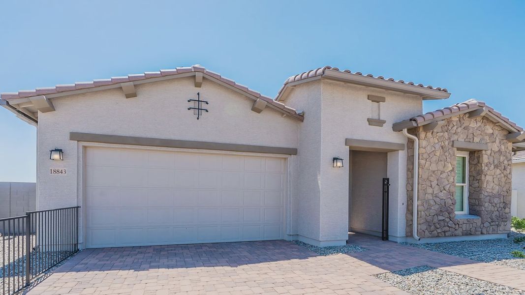 Exquisite stone facade and elegant tile roofing highlight this Windrose residence's timeless charm.