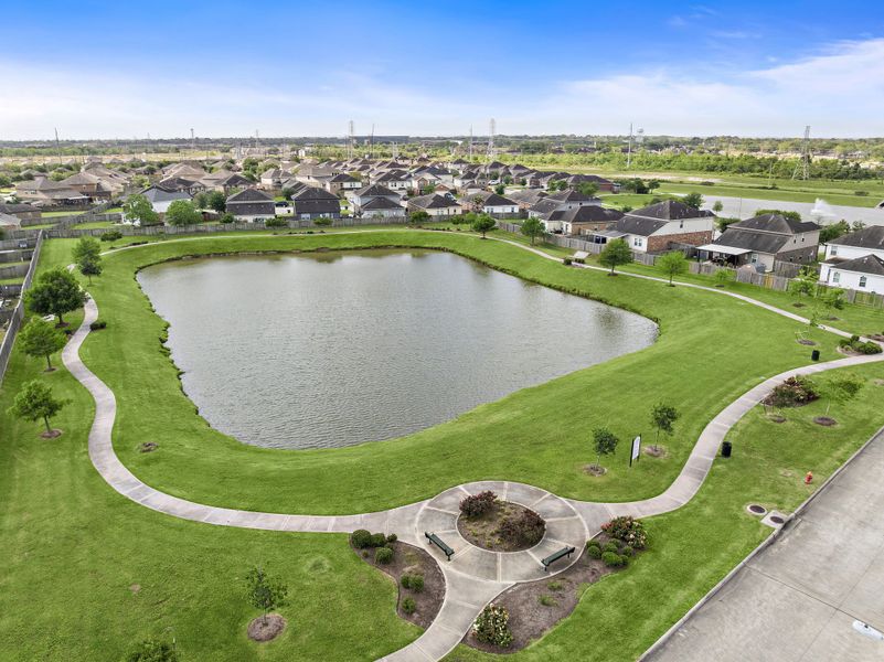 A pond surrounded by grass and buildings. A pond surrounded by grass and buildings.