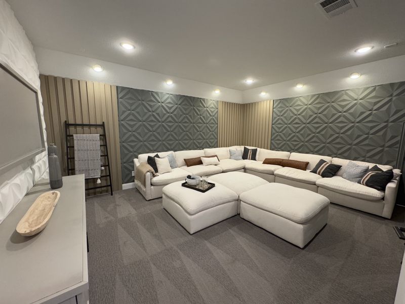 A stylish living room featuring a large sectional sofa, geometric accent wall, and modern decor elements. A stylish living room featuring a large sectional sofa, geometric accent wall, and modern decor elements.