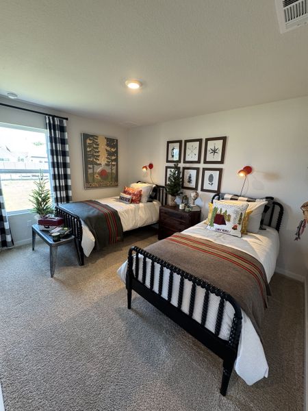 A cozy bedroom with twin beds, plaid curtains, and nature-themed decor creating a warm and inviting ambiance.