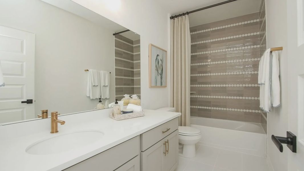 Experience elegance with sleek gray cabinetry and luxurious gold fixtures. Unique tile design enhances this Ellis Cove haven. Experience elegance with sleek gray cabinetry and luxurious gold fixtures. Unique tile design enhances this Ellis Cove haven.