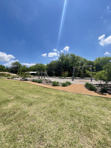 A scenic park area with swings and lush greenery in Stoneridge by Taylor Morrison (Melissa, TX).