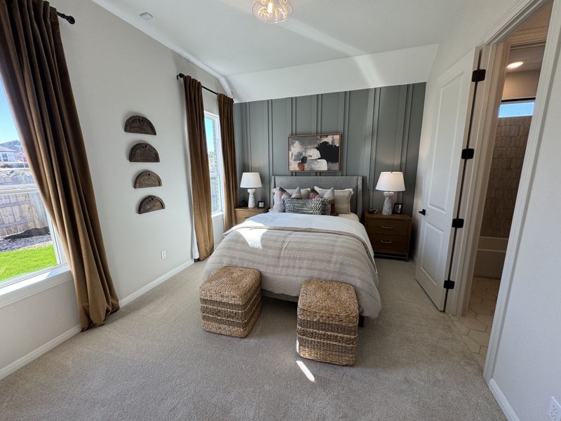 A cozy bedroom with a stylish paneled accent wall, elegant drapes, and woven baskets adding a touch of texture.