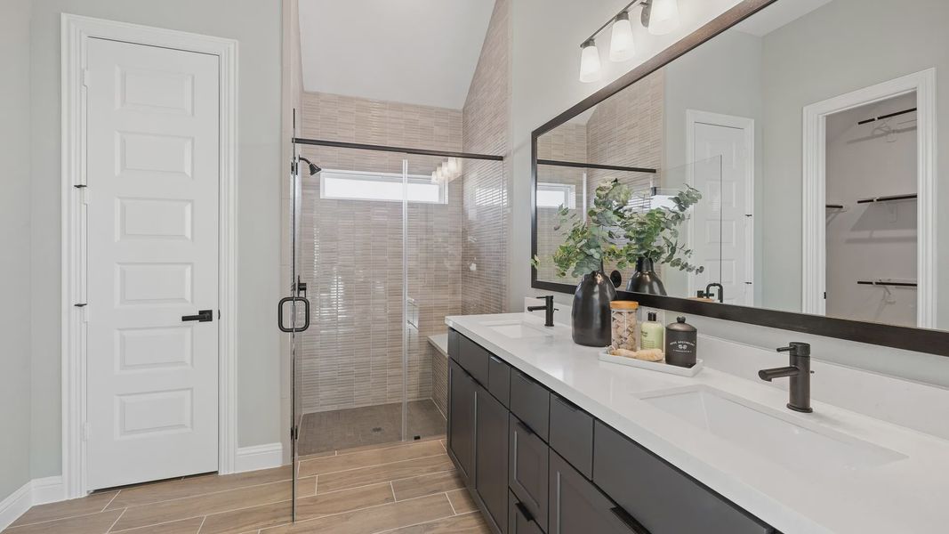 Elegantly designed bathroom showcasing quartz countertops and expansive glass shower in Southern Pointe.