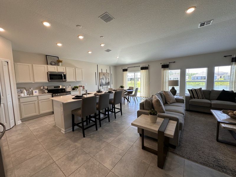 Open-concept living area with modern kitchen, cozy seating, and ample natural light through large windows. Open-concept living area with modern kitchen, cozy seating, and ample natural light through large windows.