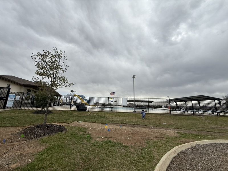A spacious community pool area with covered seating in Riverstone at Westpointe by D.R. Horton (San Antonio, TX).