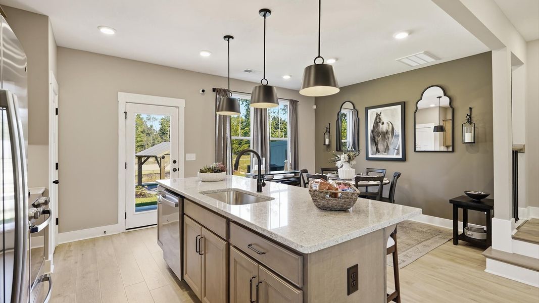 First-rate kitchen with functional layout, designer pendant lighting, and a large center island at Brookland Place