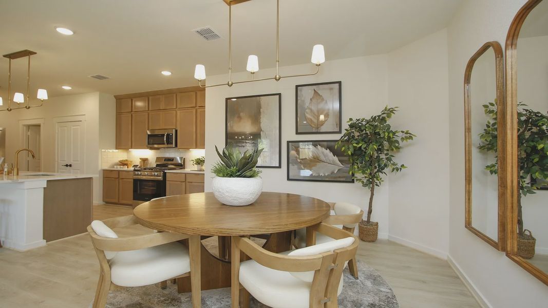 Luxurious wood accents and chic pendant lighting define this elegant dining space in Cielo community.