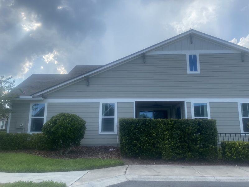 A charming gray-paneled home with manicured hedges in West End At Town Center In Nocatee by Dostie Homes (Ponte Vedra Beach, FL). A charming gray-paneled home with manicured hedges in West End At Town Center In Nocatee by Dostie Homes (Ponte Vedra Beach, FL).