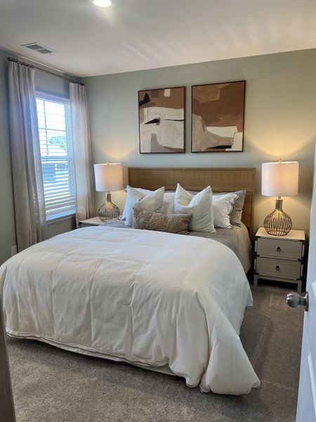 A cozy bedroom with abstract art, plush bedding, and soft lighting creating a serene and inviting atmosphere.