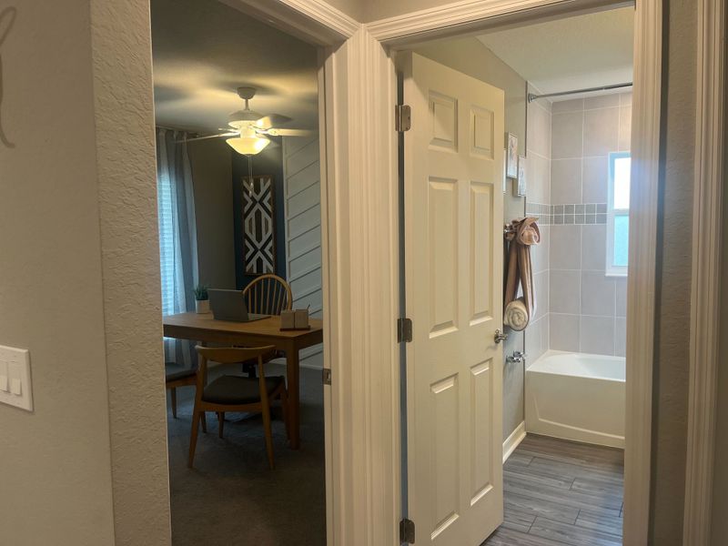 A cozy nook with a dining table, adjacent bathroom with tiled tub and window for natural light.