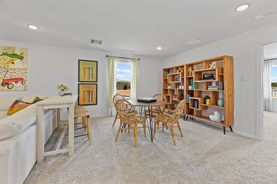 A living room with a table and chairs. A living room with a table and chairs.
