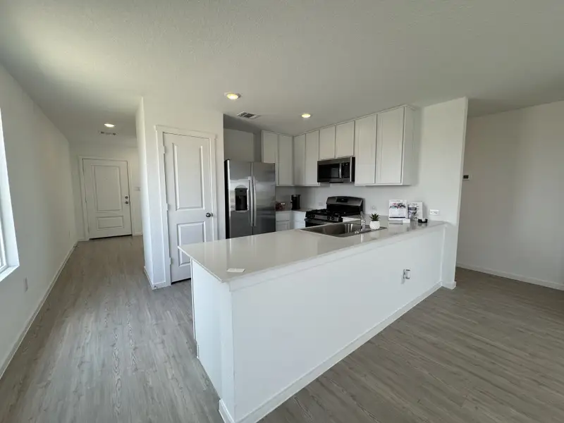 Modern kitchen with sleek white cabinetry, stainless steel appliances, an open layout, and light wood flooring. Modern kitchen with sleek white cabinetry, stainless steel appliances, an open layout, and light wood flooring.