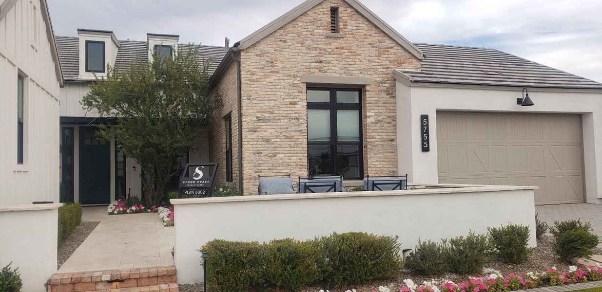 A charming brick home with a landscaped pathway in Stone Crest by Camelot Homes (Gilbert, AZ).