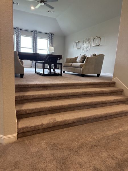 A cozy living area with plush carpeting, elegant sofas, and large windows allowing natural light to fill the space. A cozy living area with plush carpeting, elegant sofas, and large windows allowing natural light to fill the space.