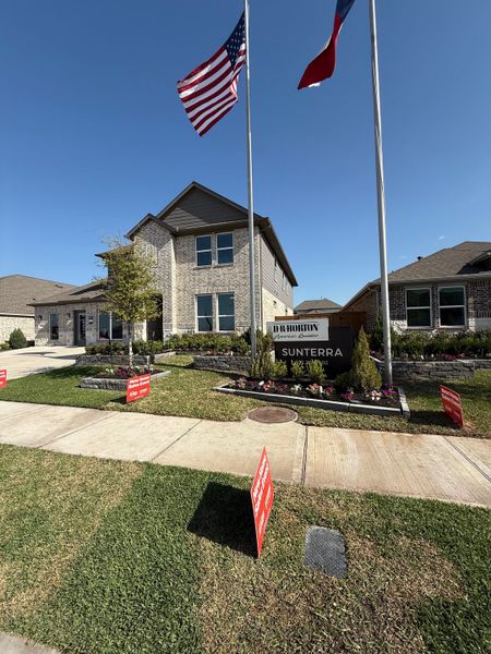 A beautiful brick home with manicured landscaping in Sunterra by D.R. Horton, nestled in Katy, TX.
