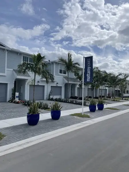 A modern townhouse with palm-lined streets in Forest by Mattamy Homes, Lake Worth, FL.