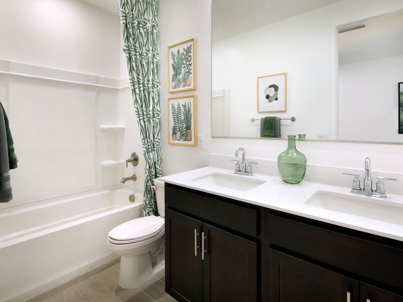 The secondary bath features dual vanities, perfect for the kids.