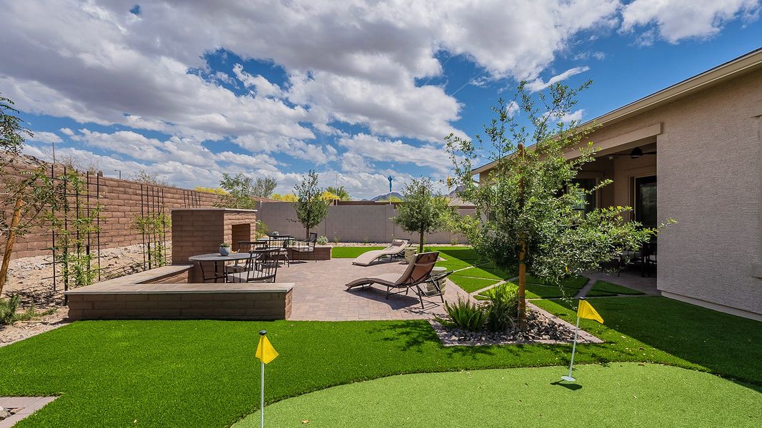 Experience refined outdoor living with a sophisticated patio fireplace and pristine putting green in Hacienda at Estrella.