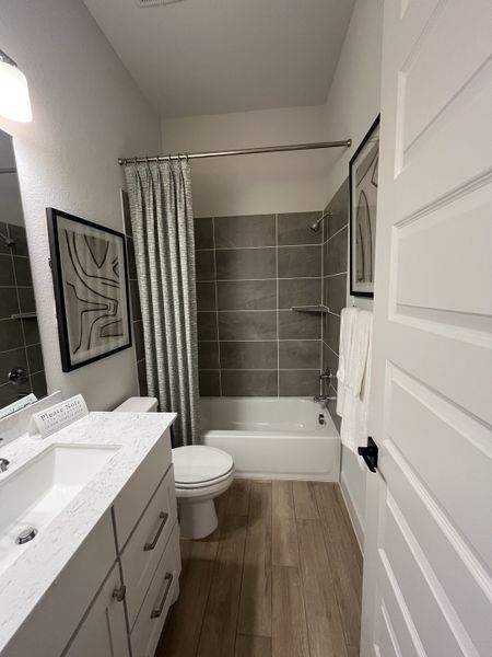 A modern bathroom featuring sleek tile, a marble countertop, and elegant accents for a timeless feel.