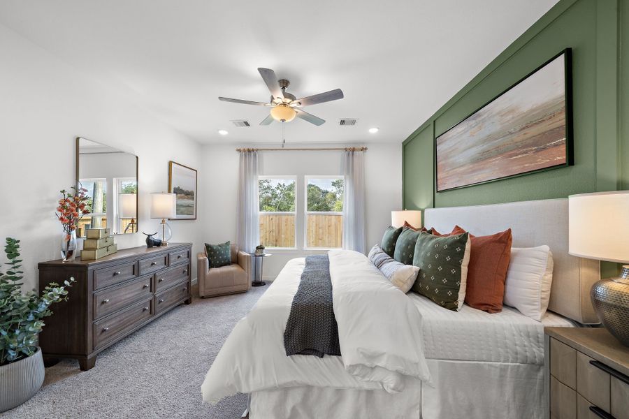 A bedroom with a large bed and a fan.