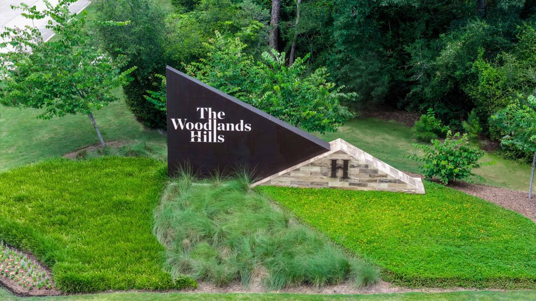 Entrance to the The Woodlands Hills 65′ community in Willis, TX, featuring signage and landscaping (Image 1). Entrance to the The Woodlands Hills 65′ community in Willis, TX, featuring signage and landscaping (Image 1).