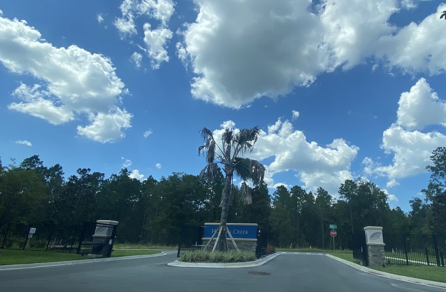 Entrance with lush greenery and blue sky at SilverLeaf by MasterCraft Builder Group in St. Augustine, FL.