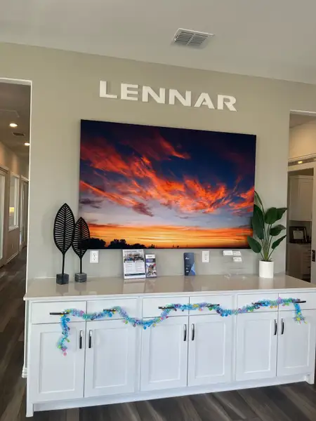 A modern interior with a decorative cabinet, vibrant sunset artwork, and stylish decor elements.
