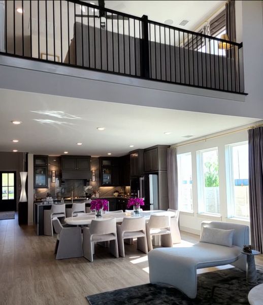 A spacious, modern open-plan living area with a stylish kitchen, elegant dining set, and a cozy lounge spot.