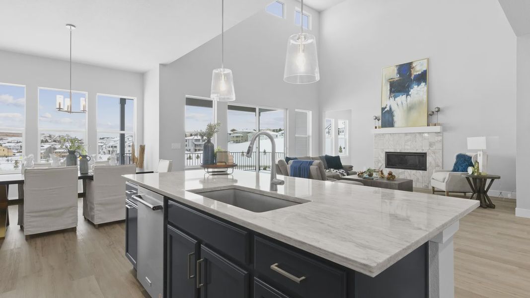 This Montaine home's kitchen boasts elegant marble counters and expansive windows, complemented by chic pendant lighting.