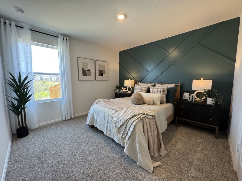 A modern bedroom with a deep teal accent wall, plush bedding, and elegant lighting. A modern bedroom with a deep teal accent wall, plush bedding, and elegant lighting.
