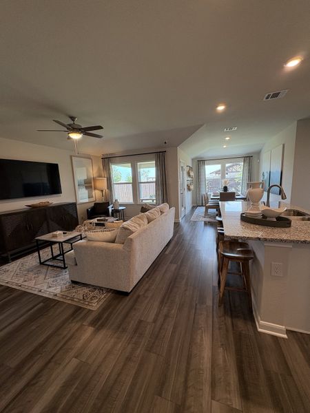 A modern, open-concept living area featuring wooden floors, cozy seating, and abundant natural light.