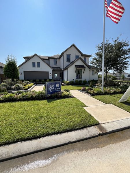 A sophisticated two-story home with manicured landscaping in Marvida by New Home Co. (Cypress, TX).