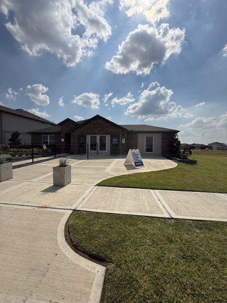 A charming brick home with a modern design in Evergreen by D.R. Horton (Rosenberg, TX) under a picturesque, cloud-dotted sky.