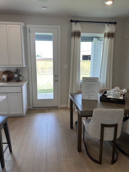 A cozy dining area with light wood floors, neutral chairs, and ample natural light from the patio door. A cozy dining area with light wood floors, neutral chairs, and ample natural light from the patio door.