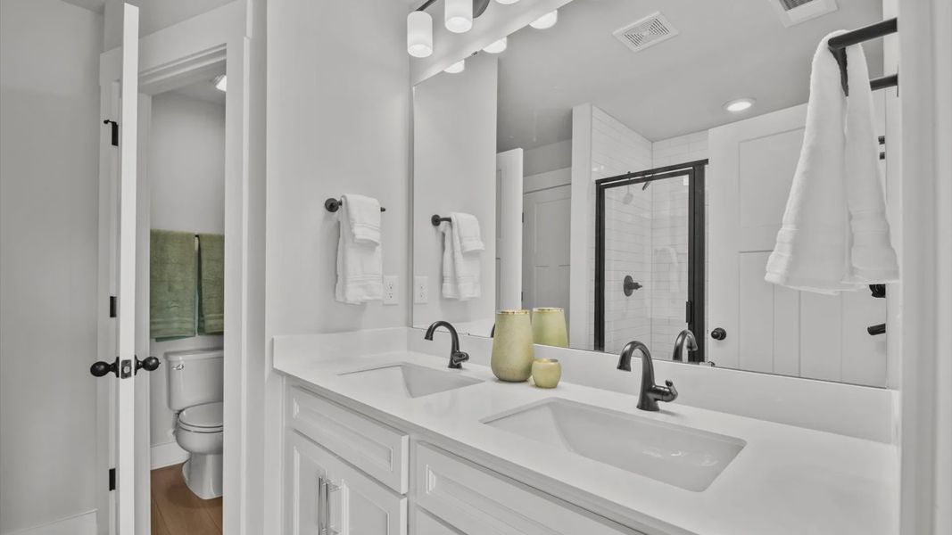 Primary bathroom with tiled walk-in shower and white quartz countertops in two story townhome in Piedmont, SC