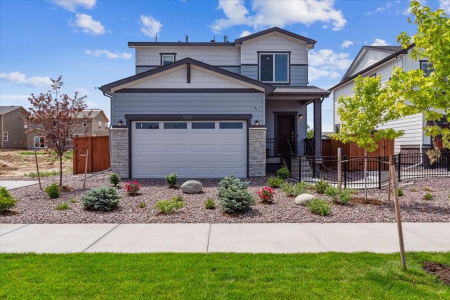 A house with a fence and a yard with a gate.