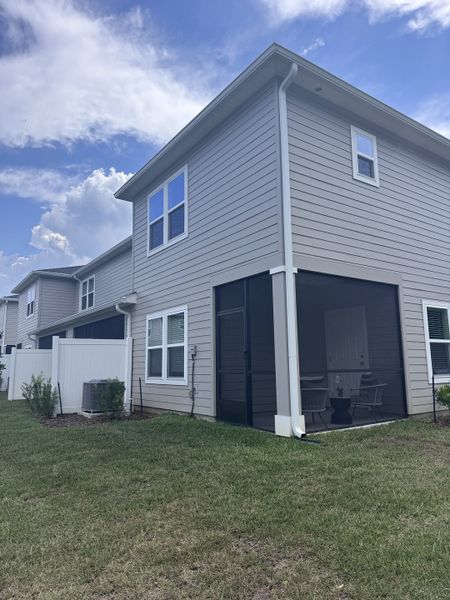 Modern townhouse in Longbay Townhomes by Lennar, featuring a fenced yard and covered patio (Middleburg, FL).