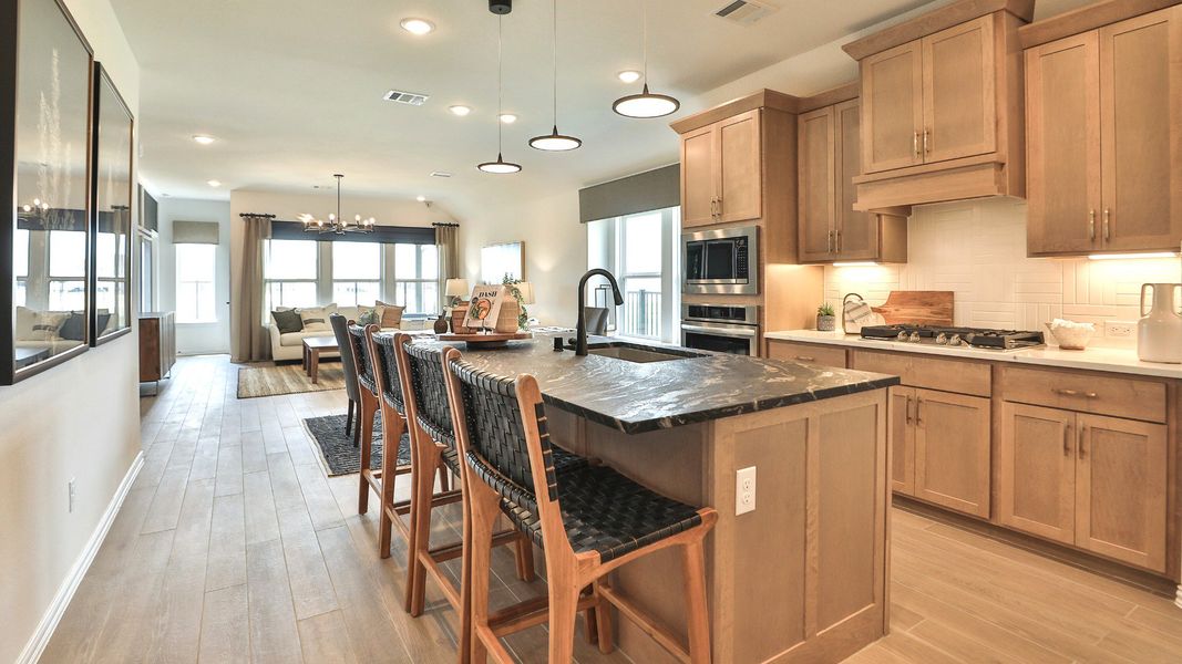 Exquisite Bridgeland home features a chic kitchen with luxurious stone countertops and sleek pendant lighting. Exquisite Bridgeland home features a chic kitchen with luxurious stone countertops and sleek pendant lighting.